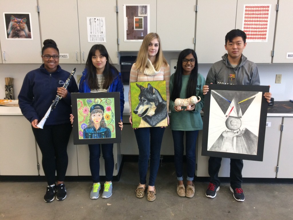 RHS Fine Arts students pose with their art, displaying a clarinet, a sculpture and flat artwork