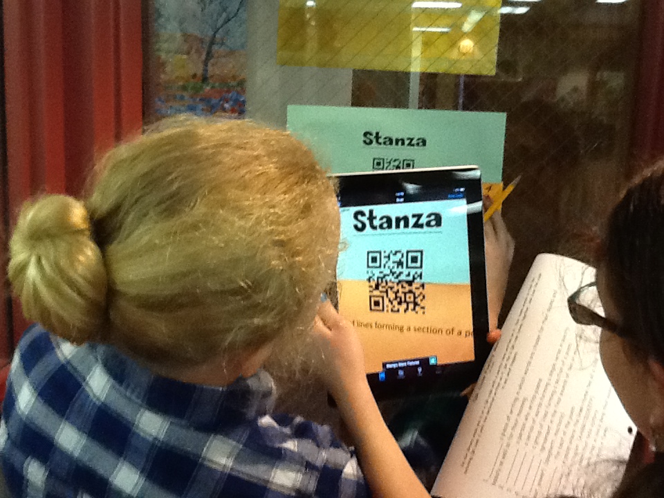 two students looking at an Ipad with the screen titled stanza and QR code