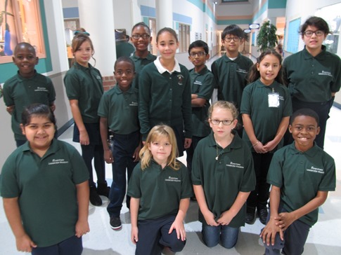 a group of students wearing green riverchase elementary shirts
