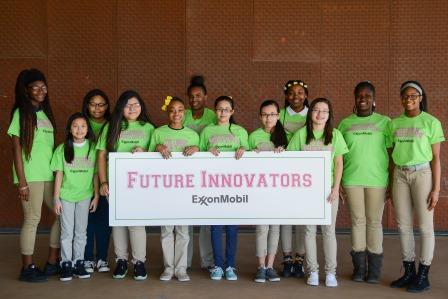 A group of female students holding a sign that says Future Innovators, Exxon Mobile