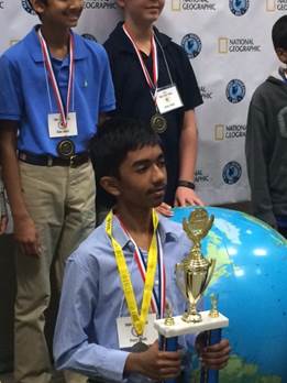 7th grade student, Pranay Varada holding his trophy for winning the State Geography Bee.