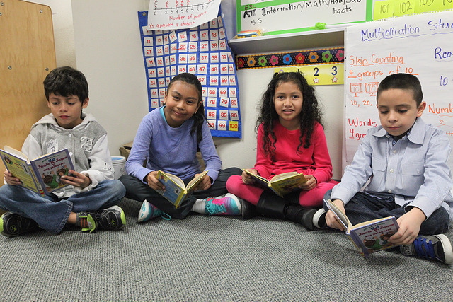 4 students sitting on the floor reading