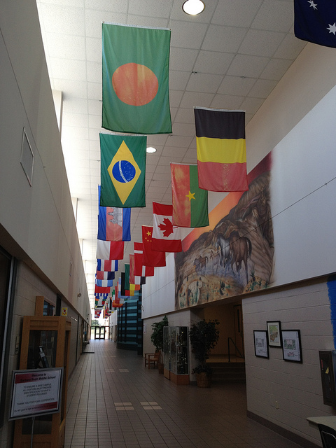 a hallway in the school with various flags hanging from the ceiling