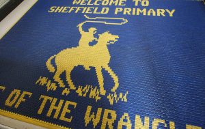 Welcome to Sheffield Primary on mat with mascot