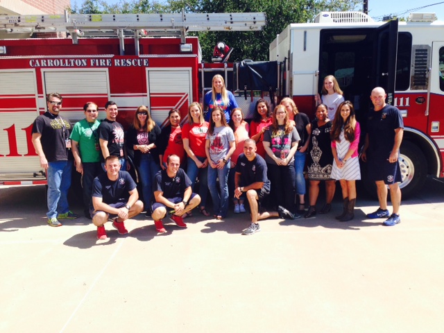 Staff of perry middle school with the fire department posing in front of a fire truck