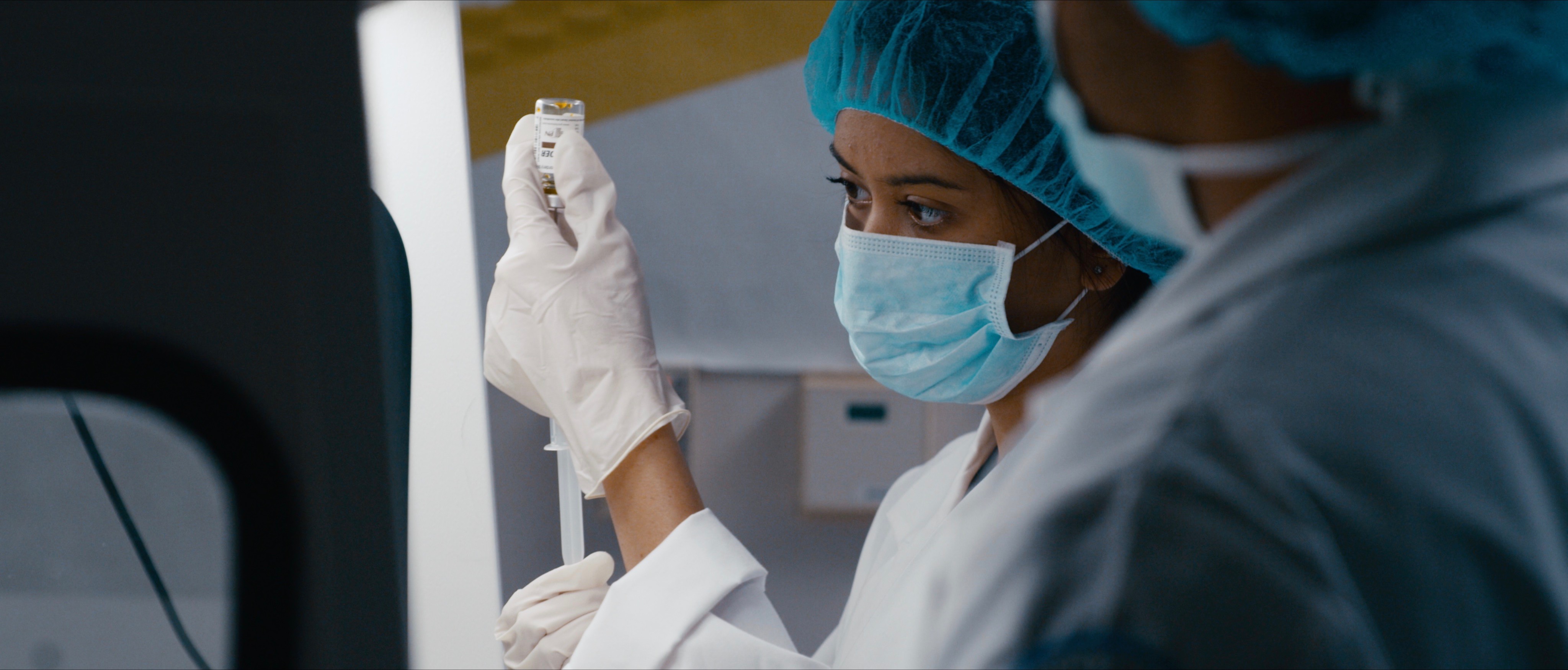 CFBISD PTA to Host a Night to Discover High School Options. Two students in the Bio Med Academy practice administering vaccines in their classroom. They are dressed in blue doctor scubs 