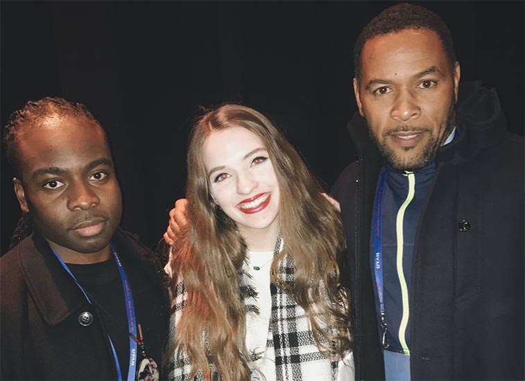 student standing at sundance with two film stars