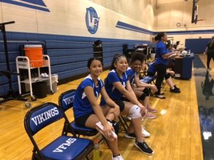 Field Volleyball Players sitting in chairs in gym